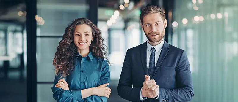 Frau und Mann aus der Finanzbranche stehen im Büro Frau und Mann aus der Finanzbranche stehen im Büro