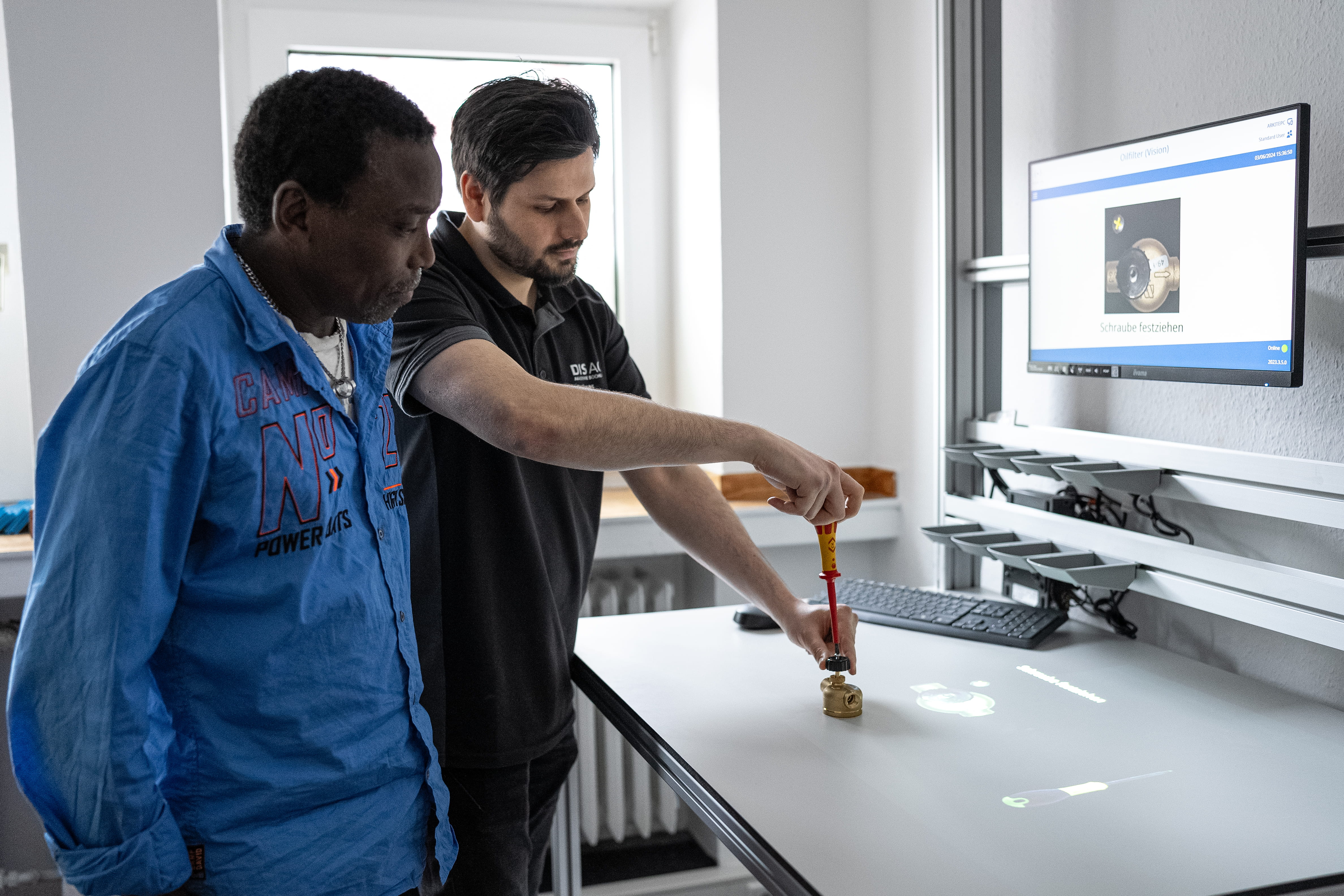 zwei-Maenner-arbeiten-gemeinsam-an-einem-technischen-Bauteil